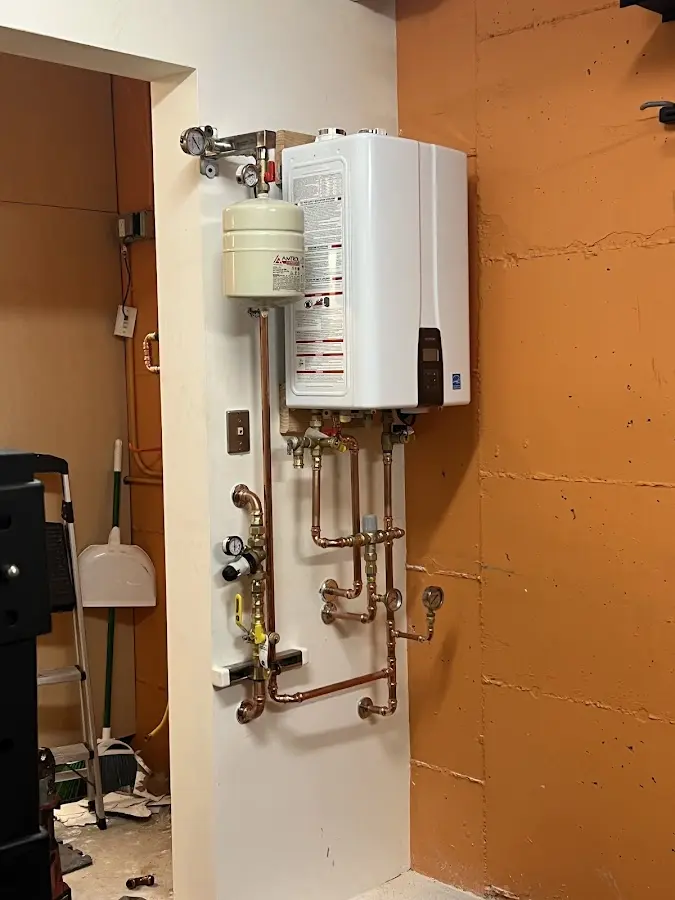 Plumbing technician inspecting water heater connections in Tittabawassee
